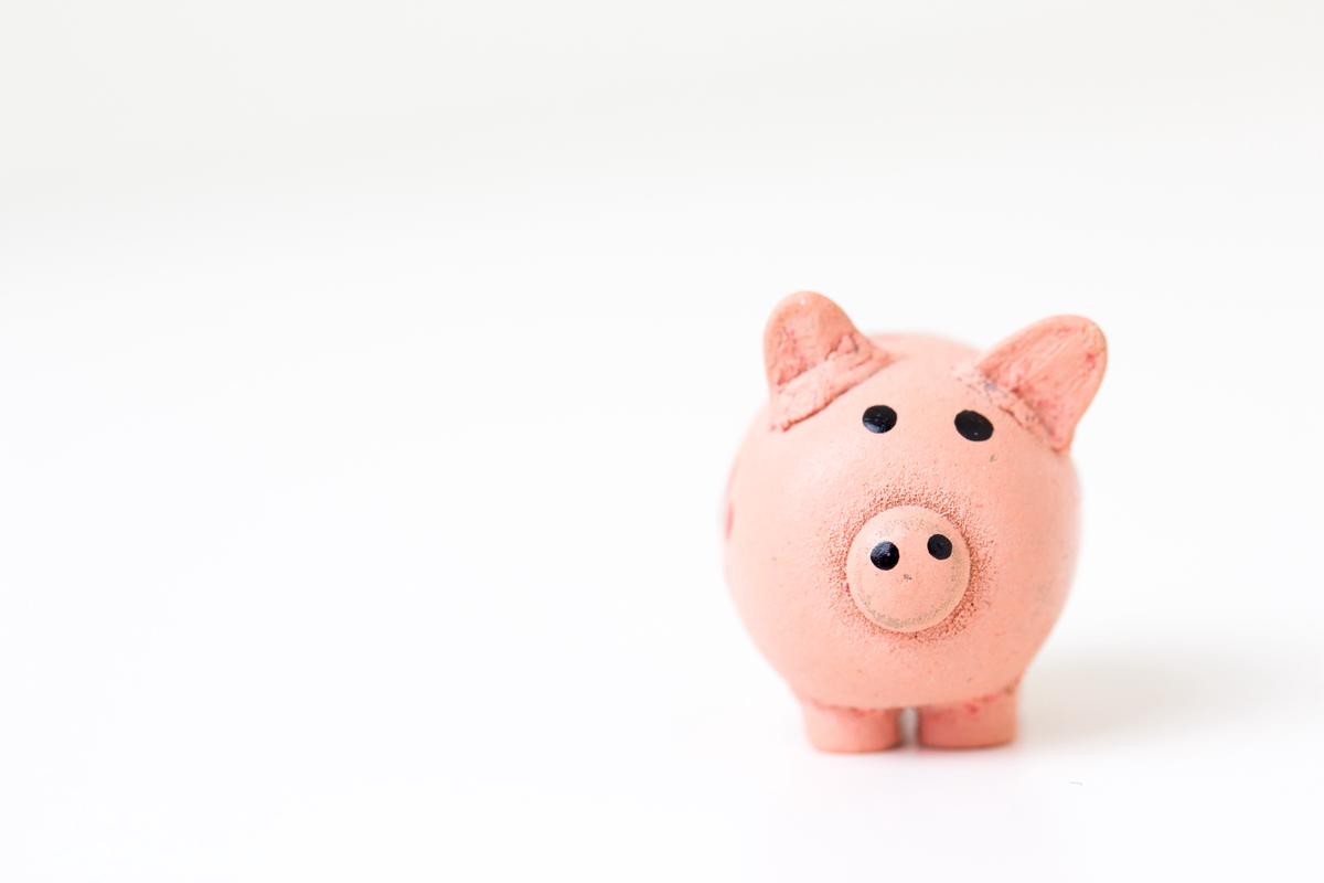 An image of a person holding a piggy bank with money coming out of it, indicating the concept of retirement funds.