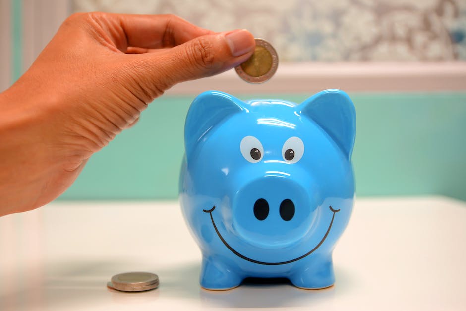 An image showing a person putting coins into a piggy bank with the words 