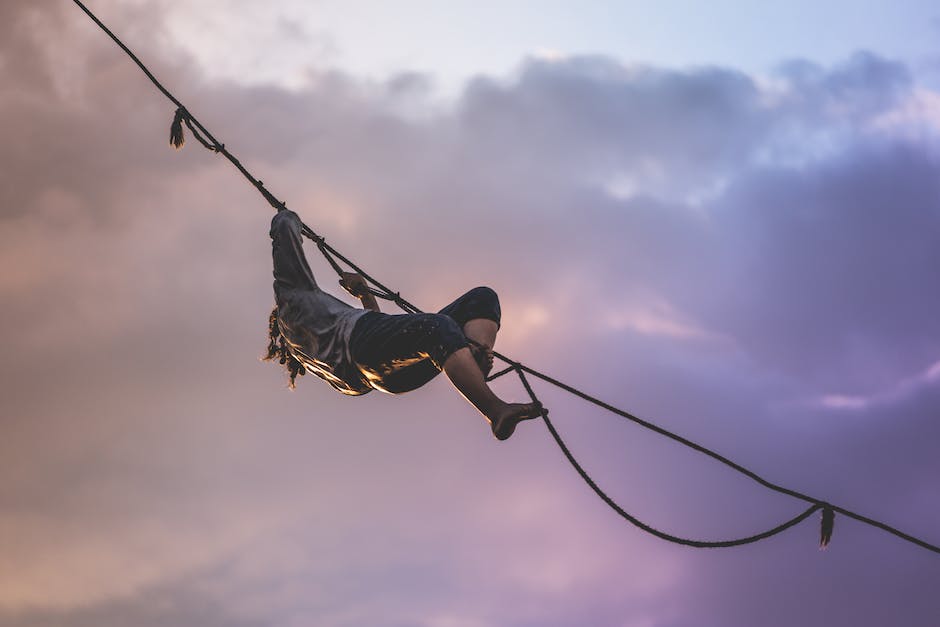 Image description: Person walking on a tightrope with lightning in the background, representing the challenges and need for resilience in trading.