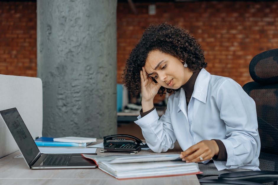 A person looking stressed while holding financial documents